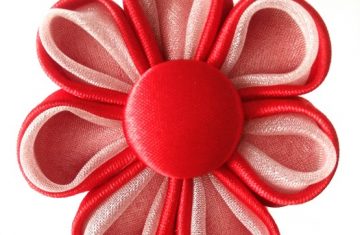 Flor kanzashi roja con botón forrado hecha a mano