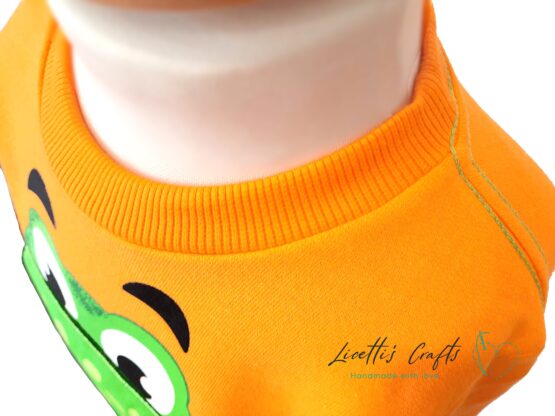 detalle cuello sudadera dinosaurio naranja