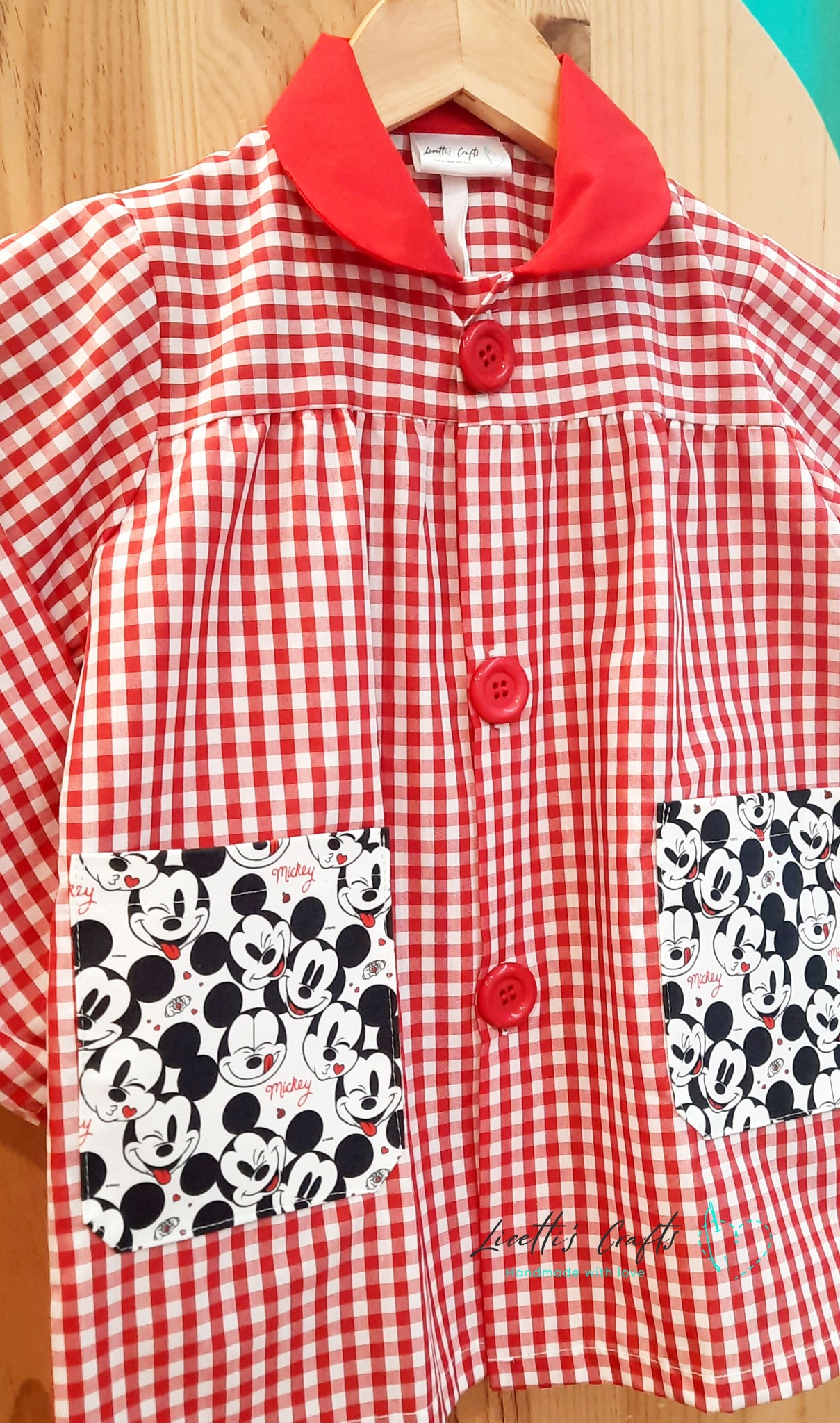 Bolsillos de Mickey Mouse en babi escolar de vichy rojo.