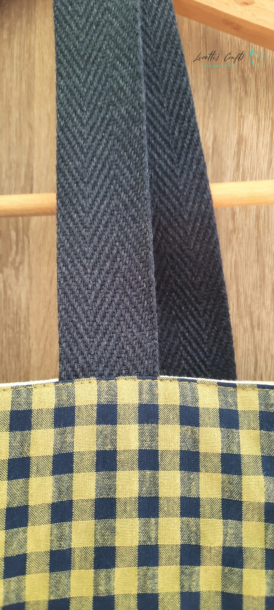 Detalle de las asas de algodón azul marino y la tela de cuadros vichy verde pistacho y azul marino del bolso tote.