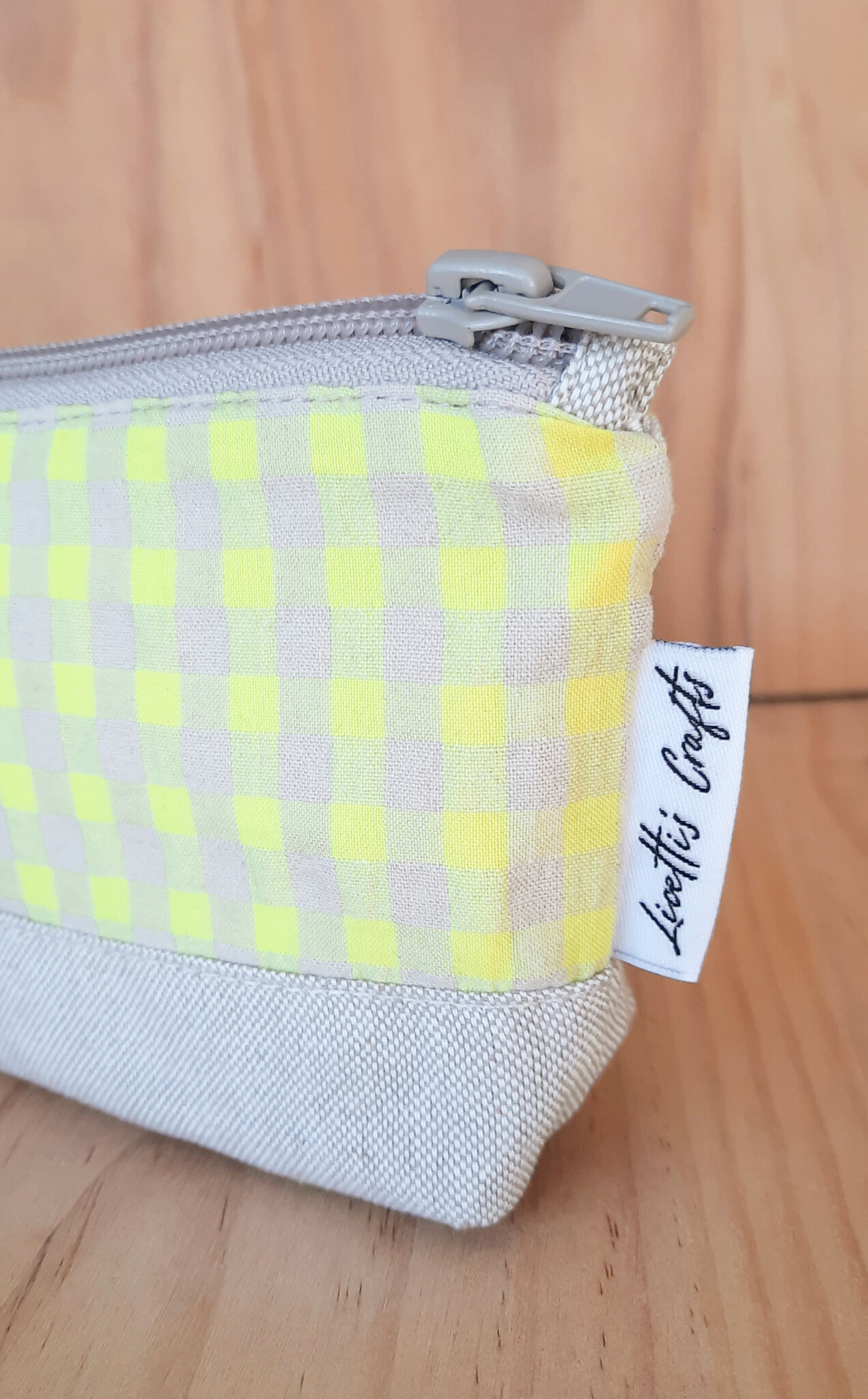 Detalle de los cuadros vichy amarillo flúor y la base de tejido natural del estuche.